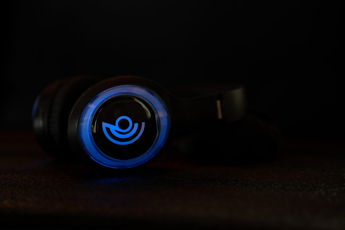 Ein Kopfhörer mit blau leuchtendem Ring auf dunklem Grund